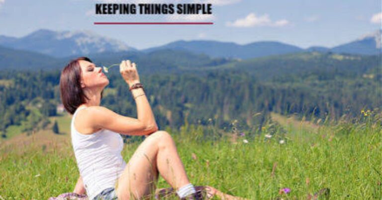 A person sitting peacefully outside in nature smiling while holding a warm cup of morning tea.